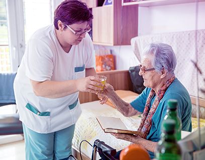 Eine Pflegerin kümmert sich um eine alte Dame. #Gib8aufGrippeschutz