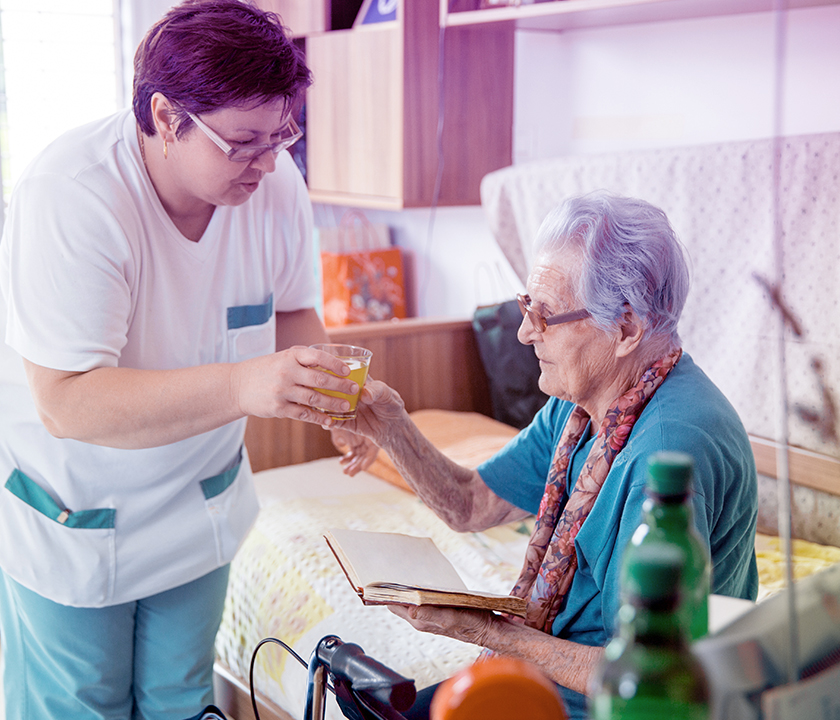 Eine Pflegerin kümmert sich um eine alte Dame. #Gib8aufGrippeschutz