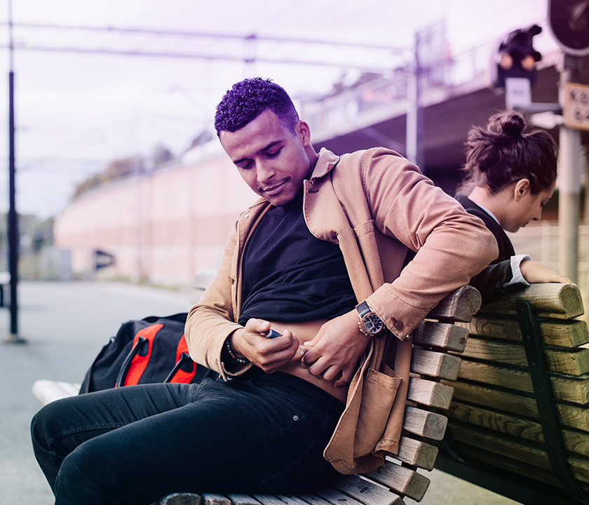 Chronisch erkrankter Mann sitzt auf einer Bank und checkt seinen Gesundheitszustand. #Gib8aufGrippeschutz.