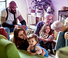 Familienmitglieder jeden Alters sitzen beisammen und verbringen eine schöne gemeinsame Zeit. #Gib8aufGrippeschutz