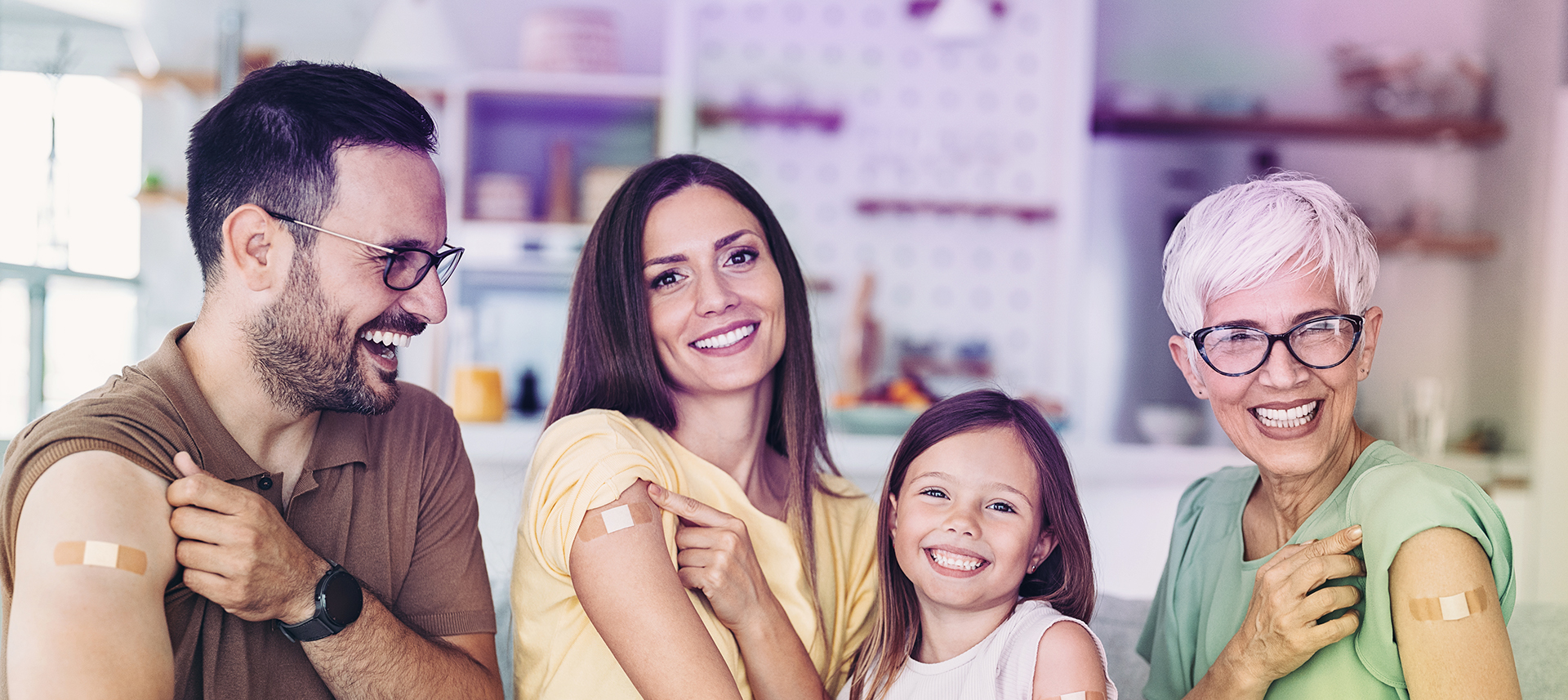 Grippeschutz für die ganze Familie: Alle Familienmitglieder präsentieren lächelnd das Pflaster nach der jährlichen Grippeschutzimpfung.