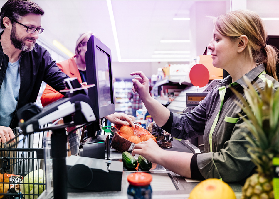 Eine Kassiererin im Supermarkt hat viel zu tun und kommt täglich mit vielen Menschen in Kontakt. #Gib8aufGrippeschutz.