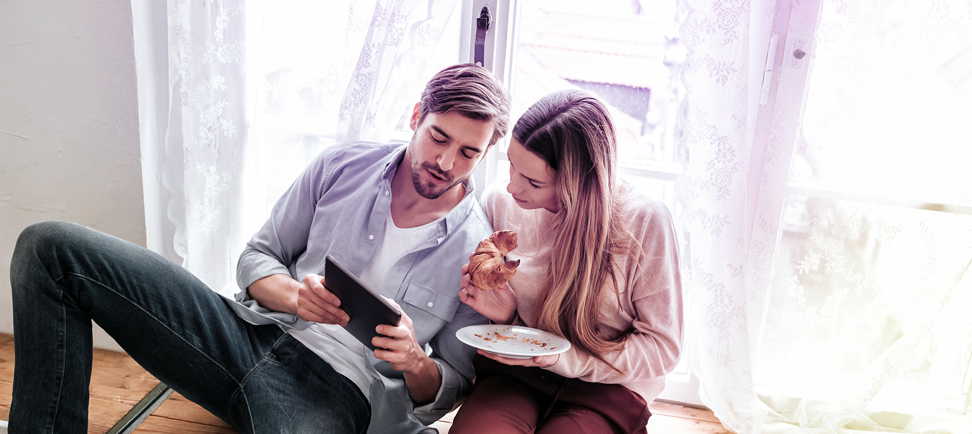 Junges Paar recherchiert auf dem iPad nach Informationsmaterialien zur Grippe und möglichen Grippeschutzmaßnahmen