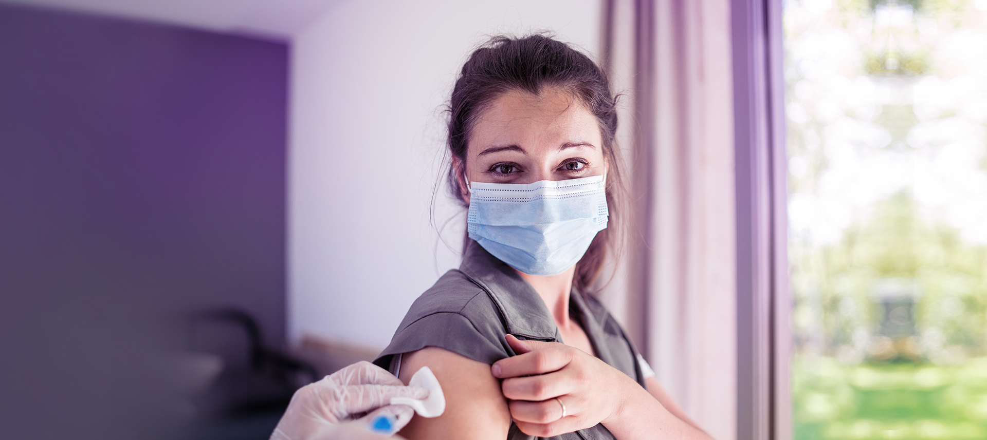 Junge Frau erhält eine jährliche Grippeschutzimpfung als Vorsorge gegen eine Influenza.