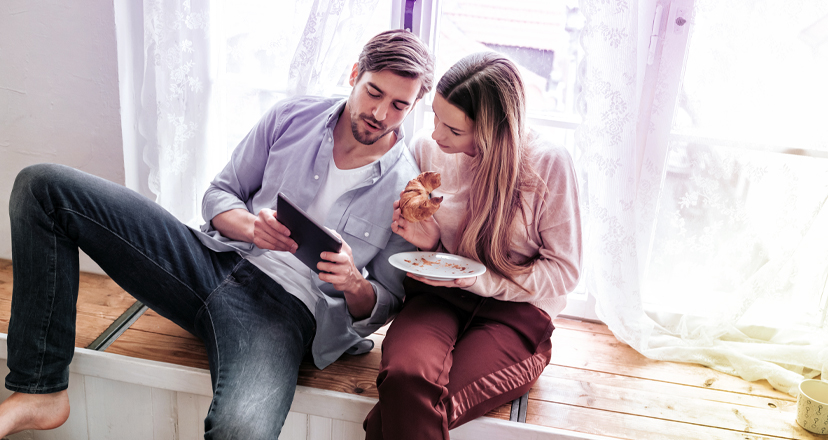 Junges Paar recherchiert auf dem iPad nach Informationsmaterialien zur Grippe und möglichen Grippeschutzmaßnahmen